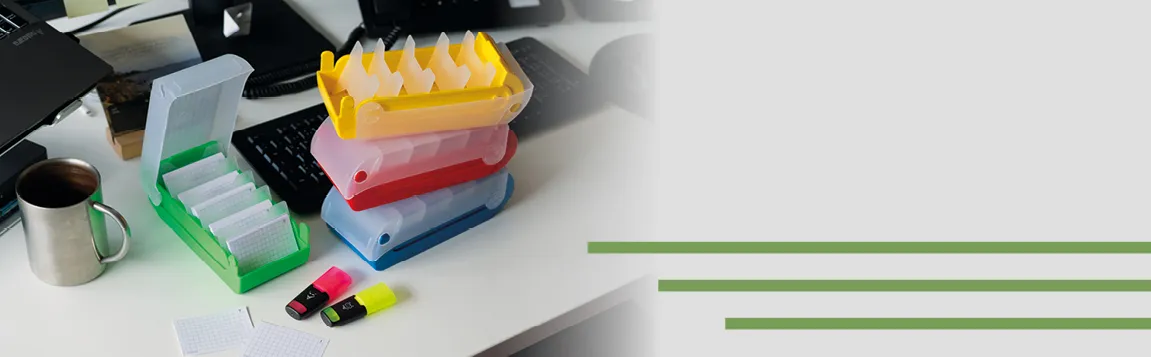Auf einen Schreibtisch liegen Karteikartenboxen in unterschiedlichen Farben. Daneben liegen 2 Mini-Textmarker
